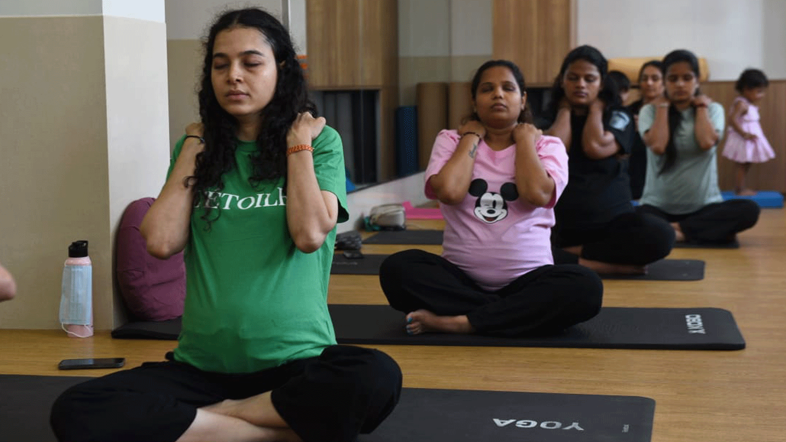 Pregnant Women Participate In A Prenatal Yoga Session