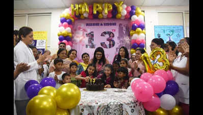 Once-conjoined twins, raised by hosp, turn 13