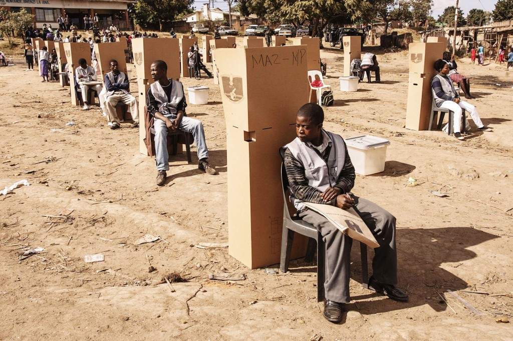 Malawian Electoral Commission workers and officers sit near the polling booths as voting procedures are repeated in Ndirande. (AFP PHOTO/AMOS GUMULIRA)