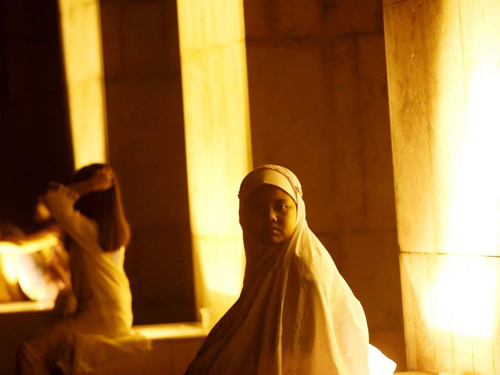 A young girl attends an evening prayer called 'tarawih' marking the first eve of the holy fasting month of Ramzan, at Istiqlal Mosque in Jakarta, Indonesia. (AP Photo/Tatan Syuflana)