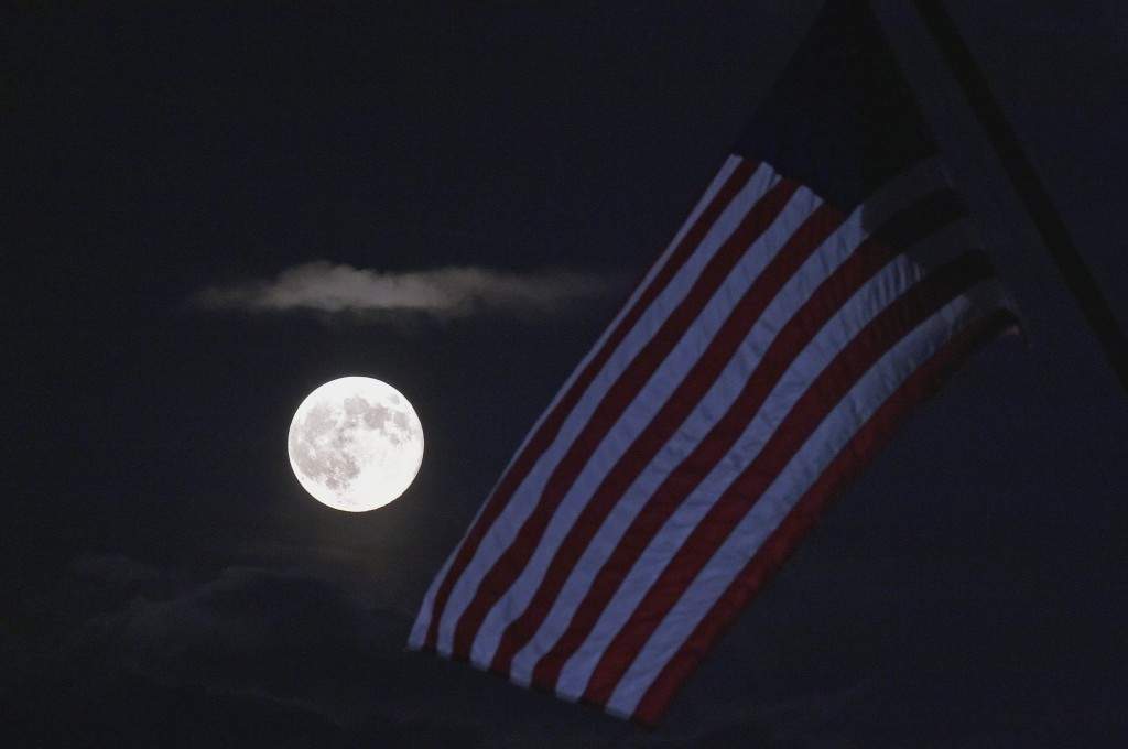 The perigee moon or 'supermoon' is seen above a US flag on the US Marine Corp War Memorial. (AFP PHOTO/Mandel NGAN)