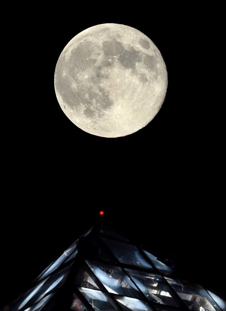 A supermoon rises behind the light on top of the Luxor Hotel and Casino in Las Vegas, Nevada. (Ethan Miller/Getty Images/AFP)
