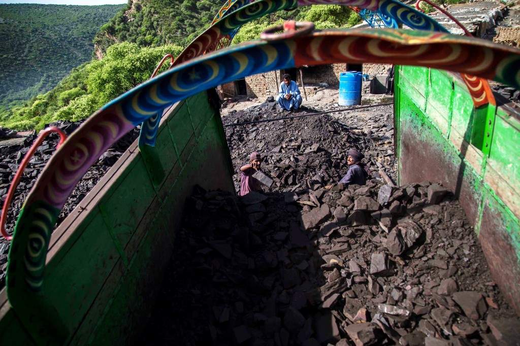 A miner loads coal onto a truck outside a mine in Choa Saidan Shah, Punjab province