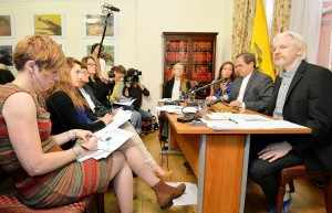 WikiLeaks founder Julian Assange listens as Ecuador's Foreign Affairs Minister Ricardo Patino speaks during a news conference at the Ecuadorian embassy in London