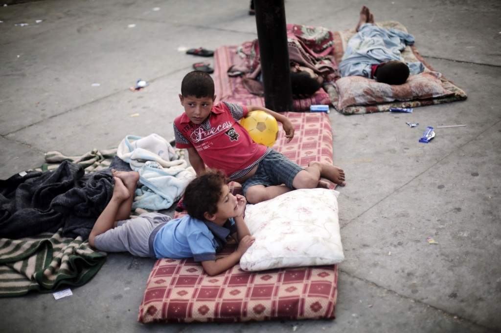 Palestinian children rest on the floor in a United Nations school where dozens of families have sought refuge after fleeing their home in fear of Israeli airstrikes. (AP Photo/Khalil Hamra)