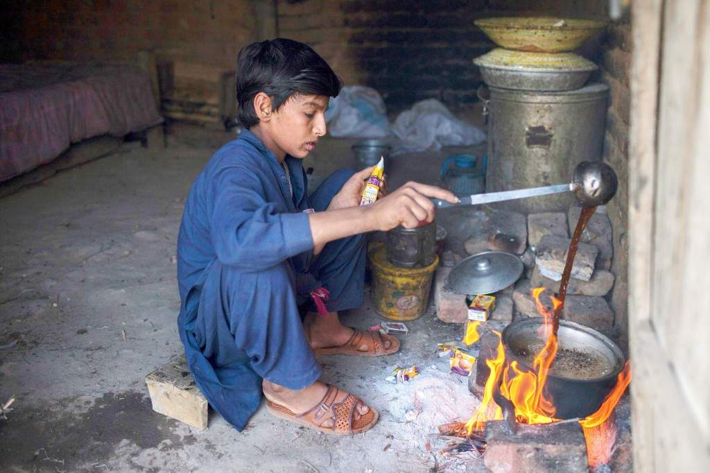 Samiullah prepares tea after finishing work at a coal mine in Choa Saidan Shah, Punjab province
