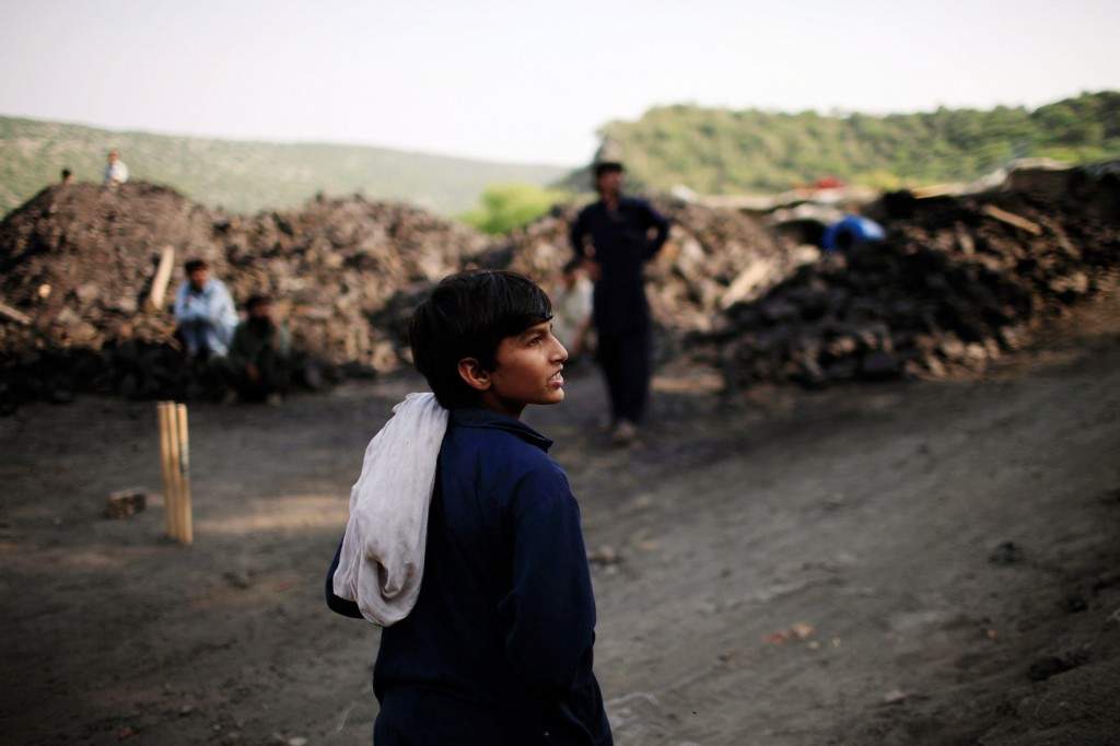 Samiullah watches the other miners play cricket at a coalfield in Choa Saidan Shah, Punjab province