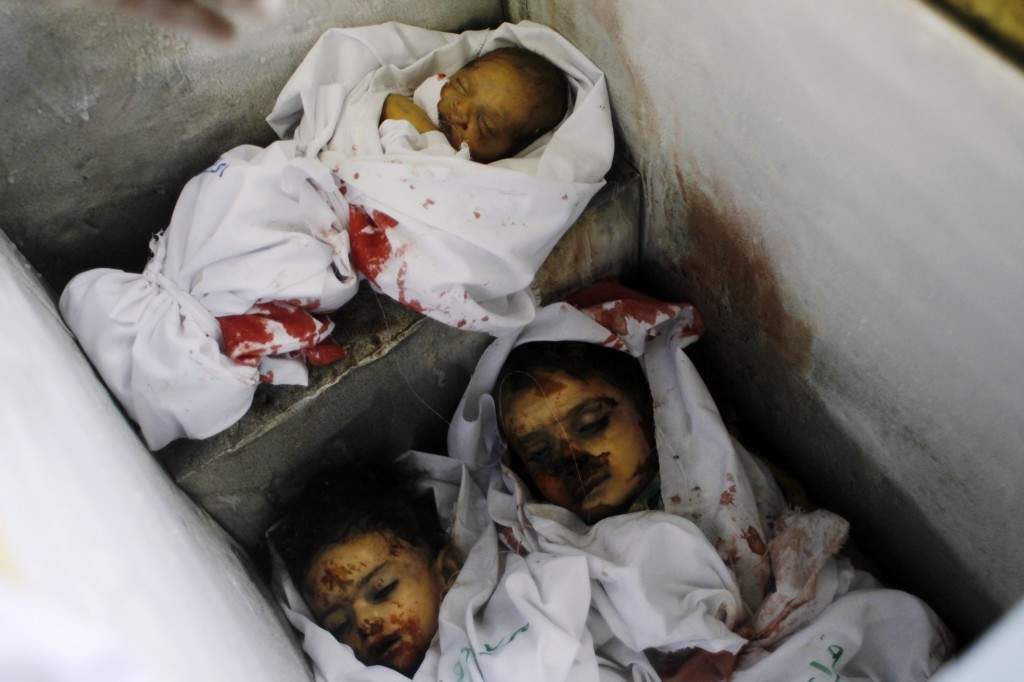 A picture taken on August 3, 2014, at the morgue in Rafah in the southern Gaza Strip shows the bodies of a baby and two children lying in an ice-cream freezer, who died along with other members of al-Ghul and Abu Jazar families after their houses were hit by an Israeli military strike. (AFP PHOTO / SAID KHATIB)