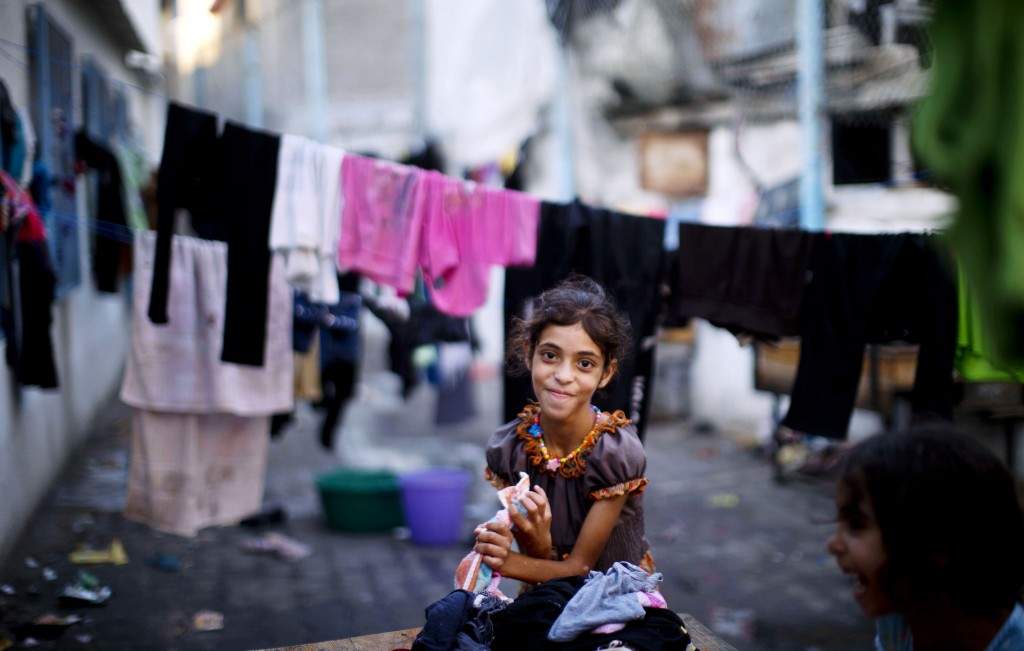 A displaced Palestinian girl squeezes out water from laundry at the Abu Hussien United Nations school in the Jabalia refugee camp in the northern Gaza Strip. (AFP PHOTO / MAHMUD HAMS)