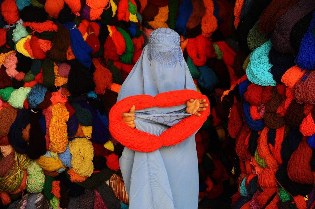 An Afghan woman buys silk yarn for weaving from a shop in Herat. (AFP PHOTO/Aref Karimi)