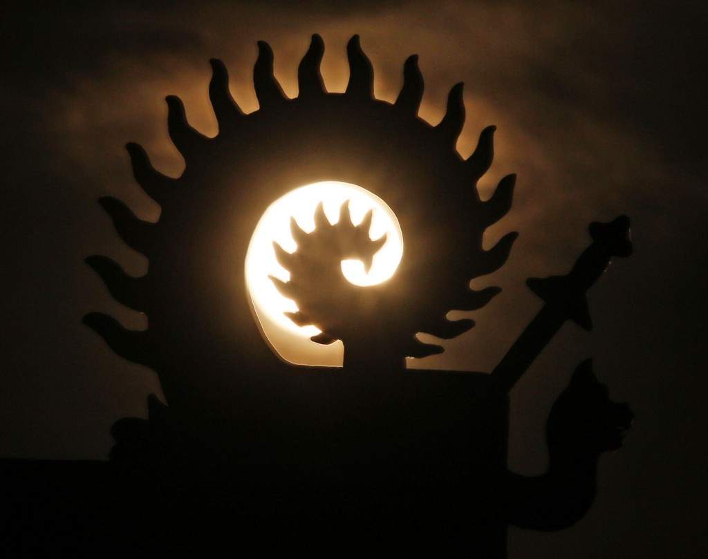 This picture shows the supermoon being seen through a statue in Jilin, northeast China's Jilin province. (AFP PHOTO)