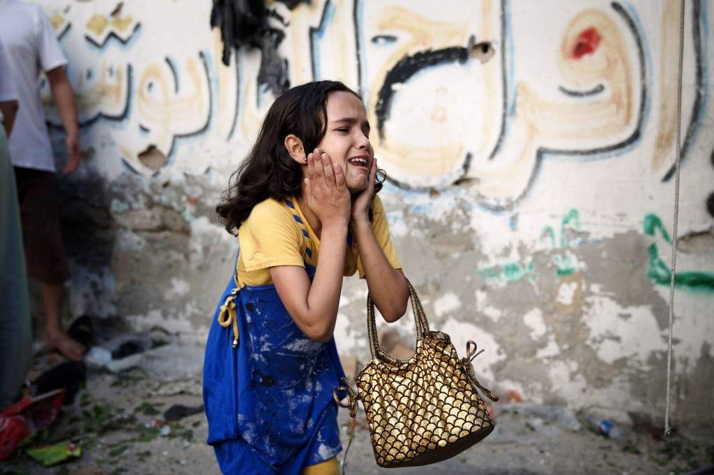 A Palestinian girl reacts at the scene of an explosion that medics said killed eight children and two adults, and wounded 40 others at a public garden in Gaza City July 28, 2014. (REUTERS/Finbarr O'Reilly)