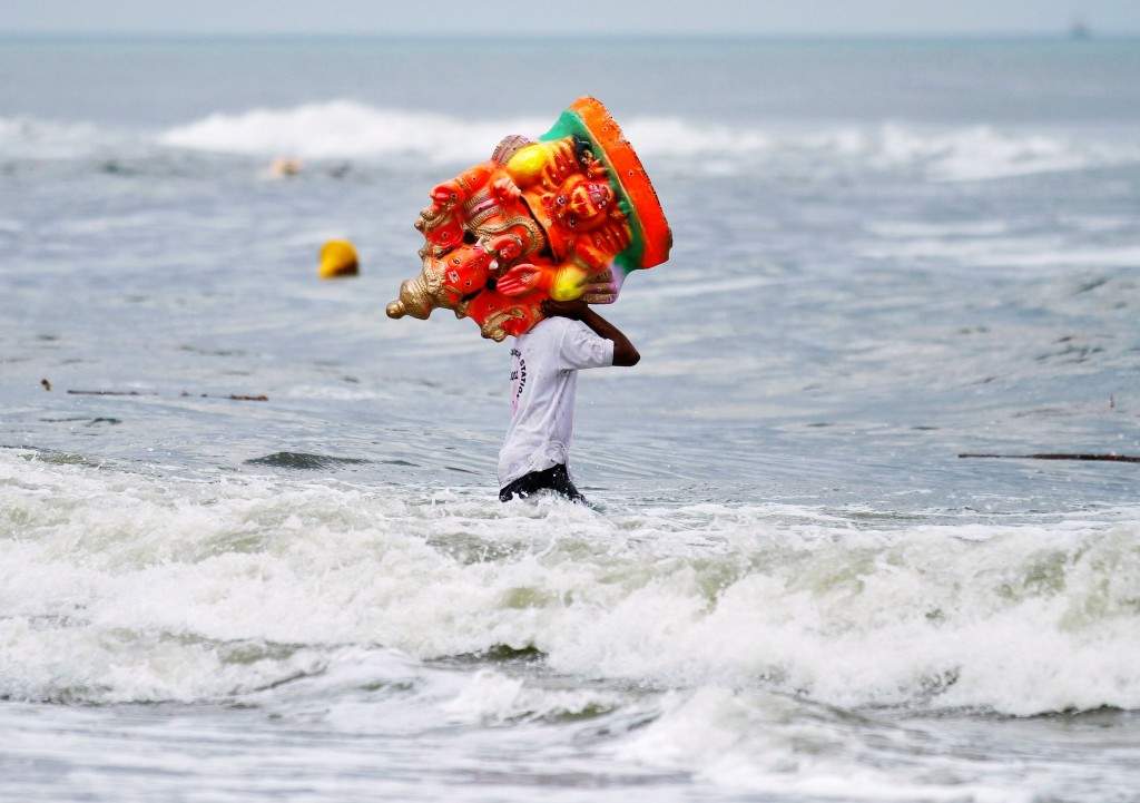 Chennai: A fisherman carries an idol of god Ganesh. (REUTERS/Babu)