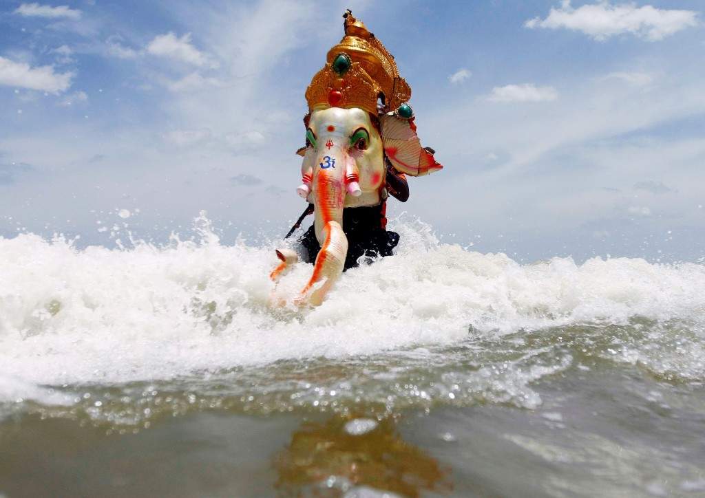 A devotee carries the head of an idol of the Hindu god Ganesh. (REUTERS/Babu)