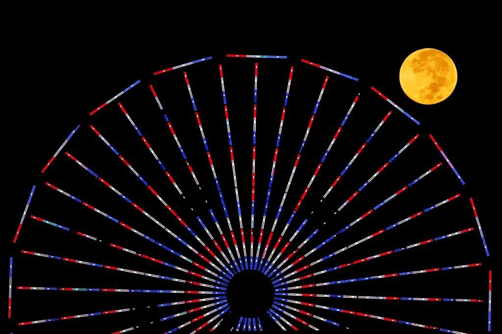 The moon is pictured behind a ferris wheel on the pier in Santa Monica, California. (REUTERS/Lucy Nicholson) 