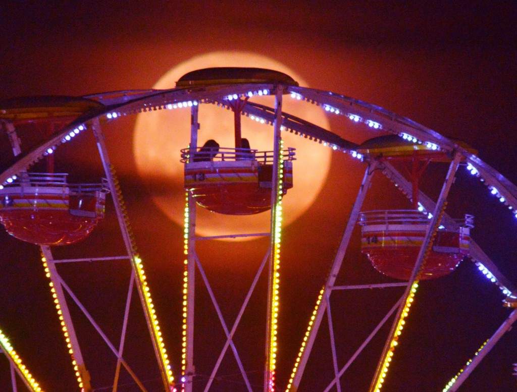 A full moon silhouettes riders at the 61st Annual Alabama National Fair in Montgomery, Ala., on Wednesday, Oct 8, 2014. (AP Photo/Montgomery Advertiser, Lloyd Gallman)