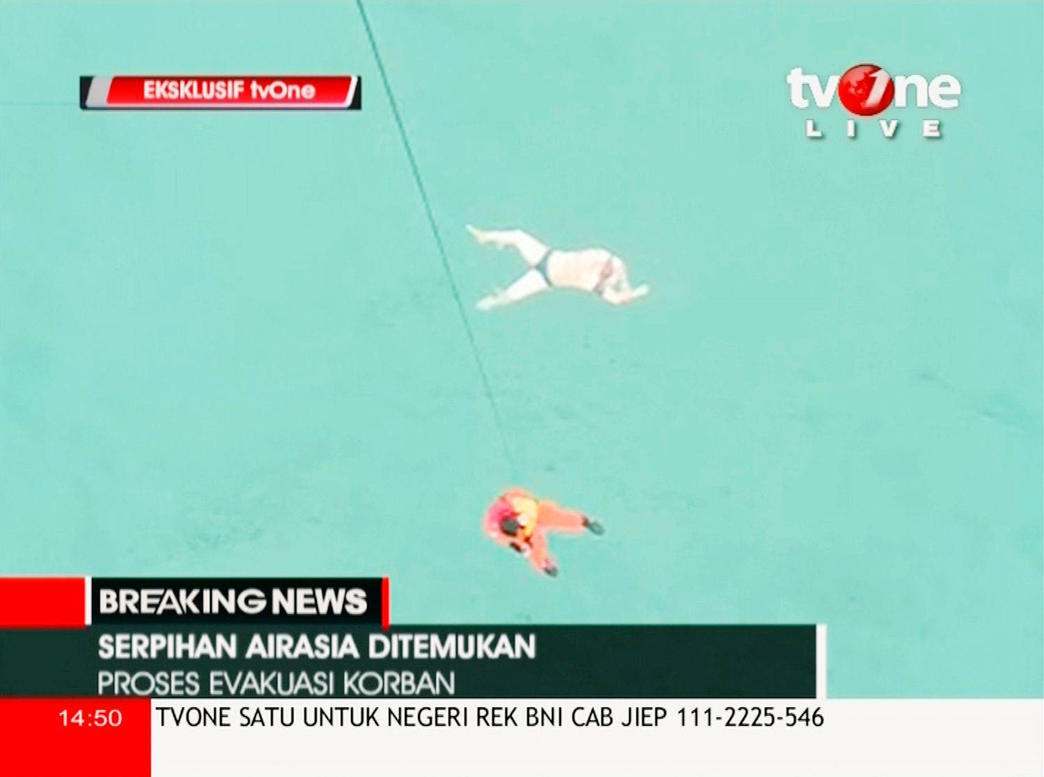 A search team member descends as a body floats in the sea off the coast of Kalimantan, Indonesia, in this still image from video. Indonesian rescuers saw bodies and luggage off the coast of Borneo island. (REUTERS/TV ONE via Reuters TV) 