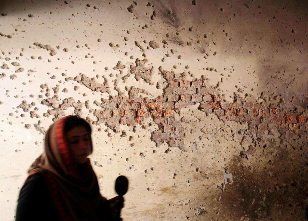 A local reporter walks past a damaged wall of the Army Public School, which was attacked by Taliban gunmen, in Peshawar. (REUTERS/Fayaz Aziz) 