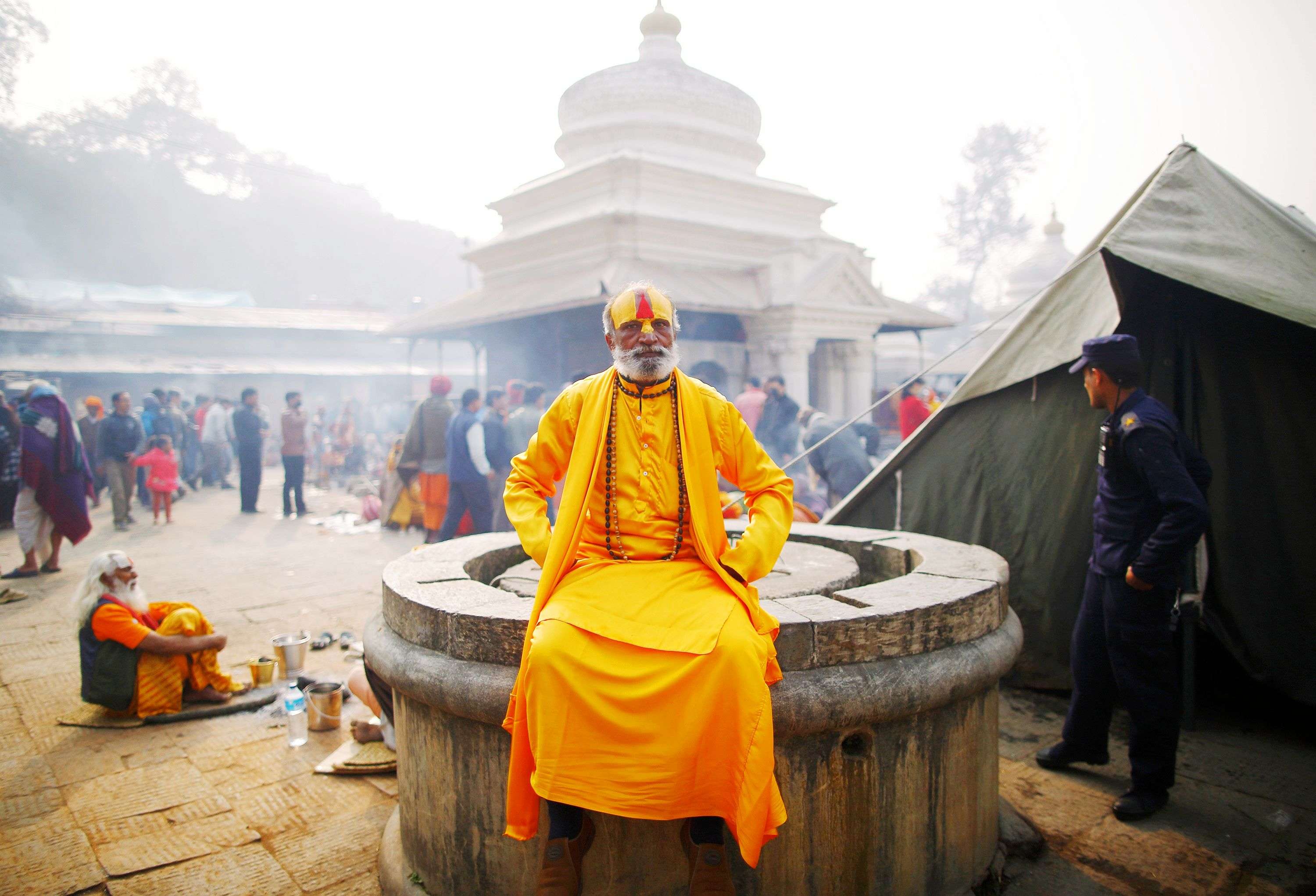 A sadhu sits on top of the well at the premises of Pashupatinath Temple in Kathmandu. (REUTERS/Navesh Chitrakar)