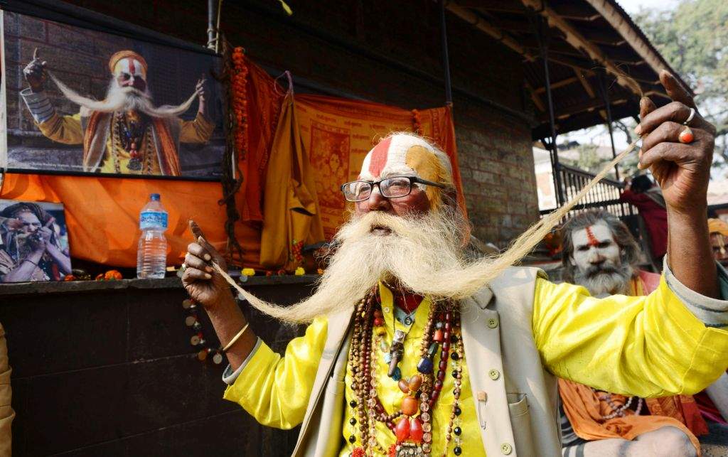 A sadhu poses with another near the Pashupatinath Temple in Kathmandu. (AFP PHOTO / PRAKASH MATHEMA)