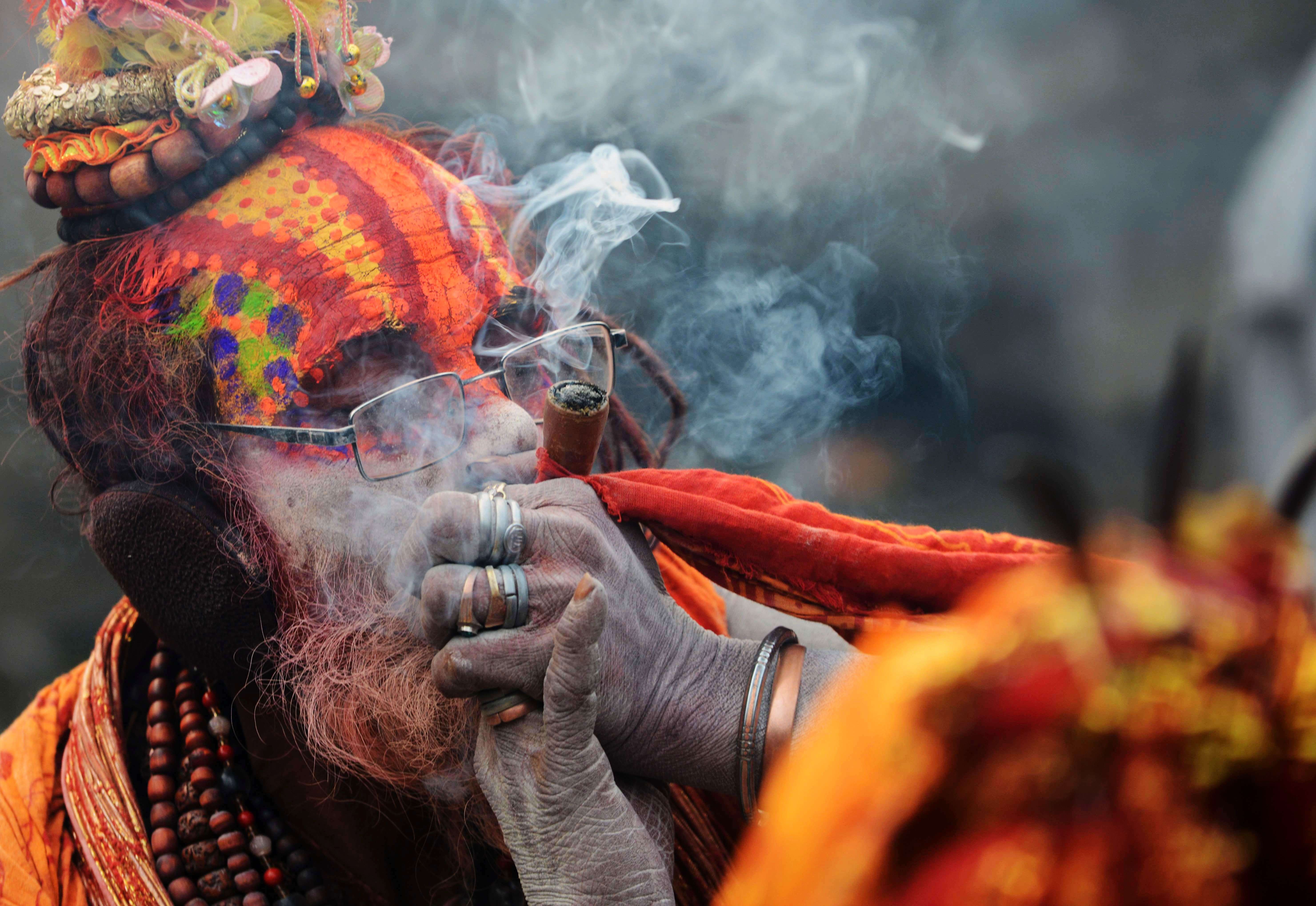 A sadhu smokes marijuana from a clay pipe as a holy offering for Lord Shiva, the Hindu god of creation and destruction, during the Maha Shivaratri festival in Kathmandu. (AFP PHOTO / PRAKASH MATHEMA)