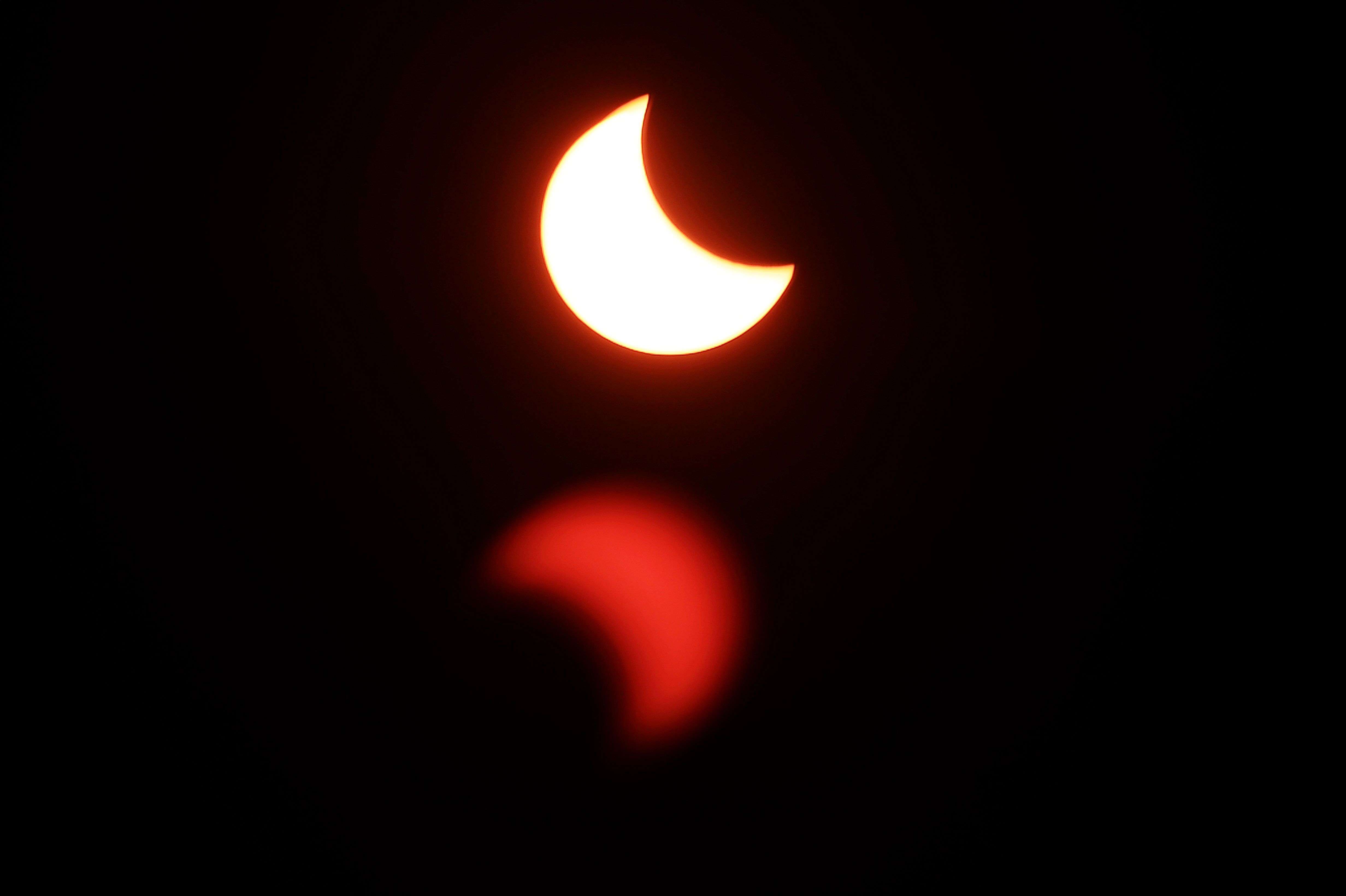 A partial solar eclipse is visible over Strasbourg, eastern France. (AFP PHOTO / FREDERICK FLORIN) 