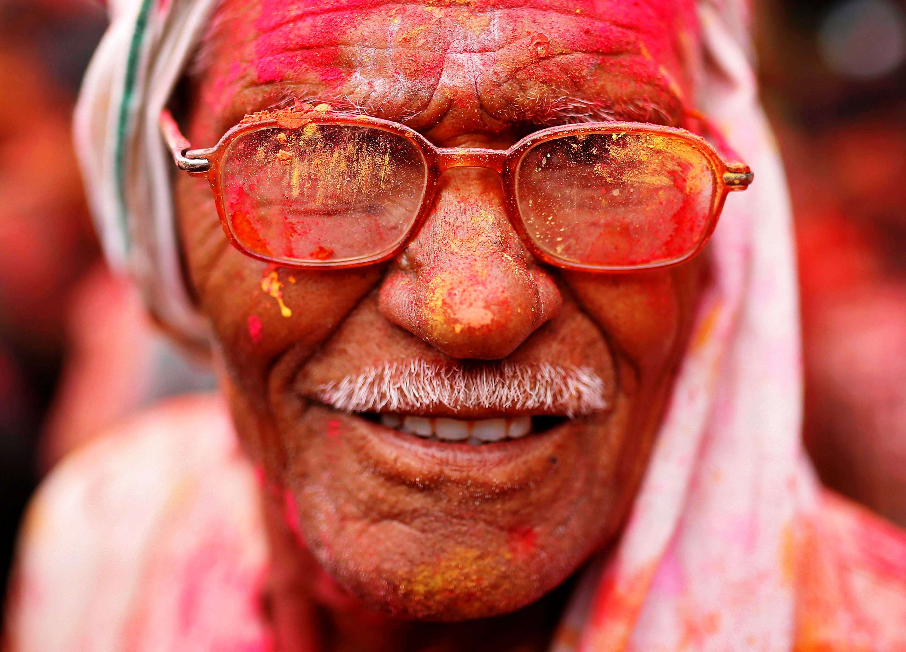 A man with his face daubed in colours celebrates "Lathmar Holi" at Nandgaon