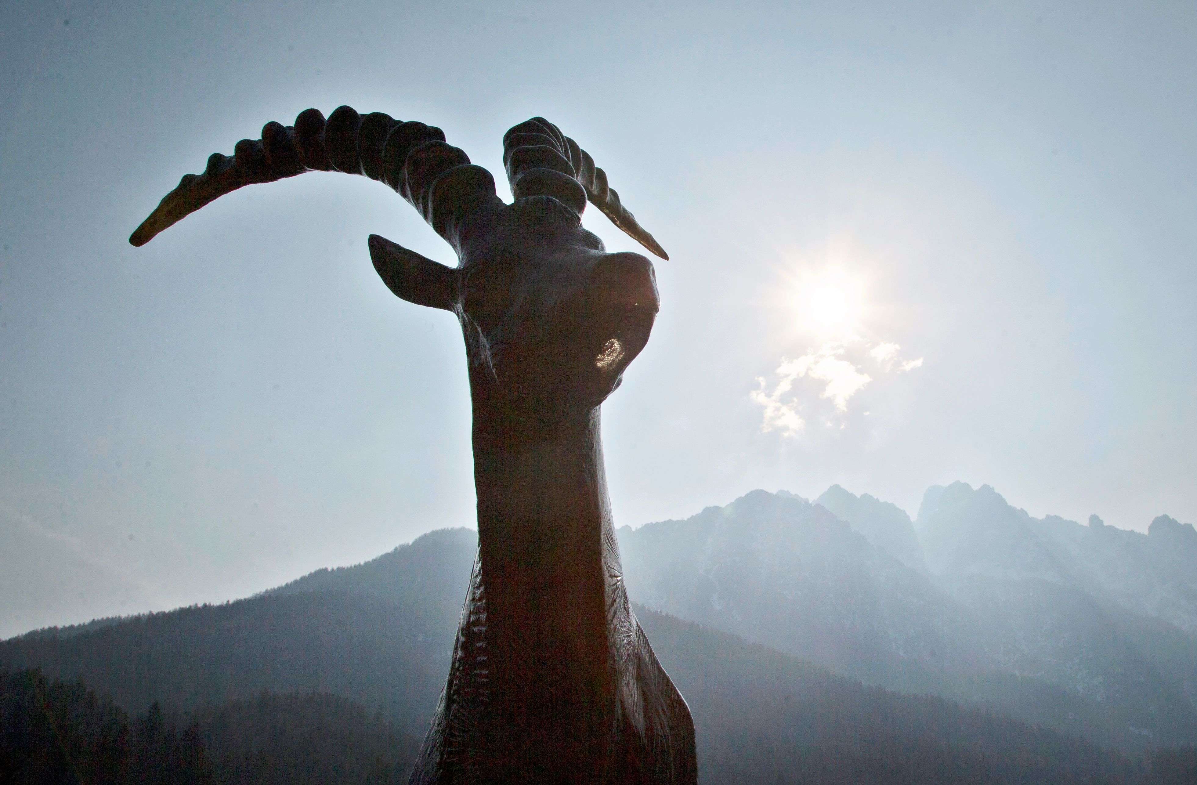 A solar eclipse is seen behind a statue of an ibex in Kranjska Gora, Slovenia. An eclipse is darkening parts of Europe on Friday in a rare solar event that won't be repeated for more than a decade. (AP Photo/Darko Bandic)