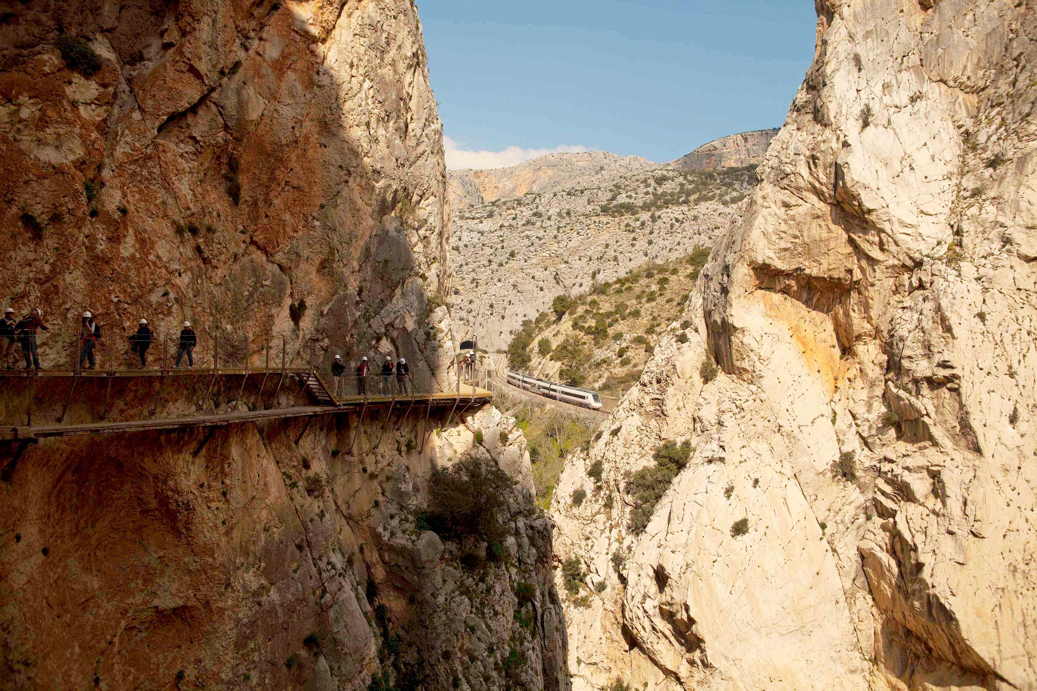 Train is seen as people  walk along the new Caminito del Rey walkway. (Reuters)  