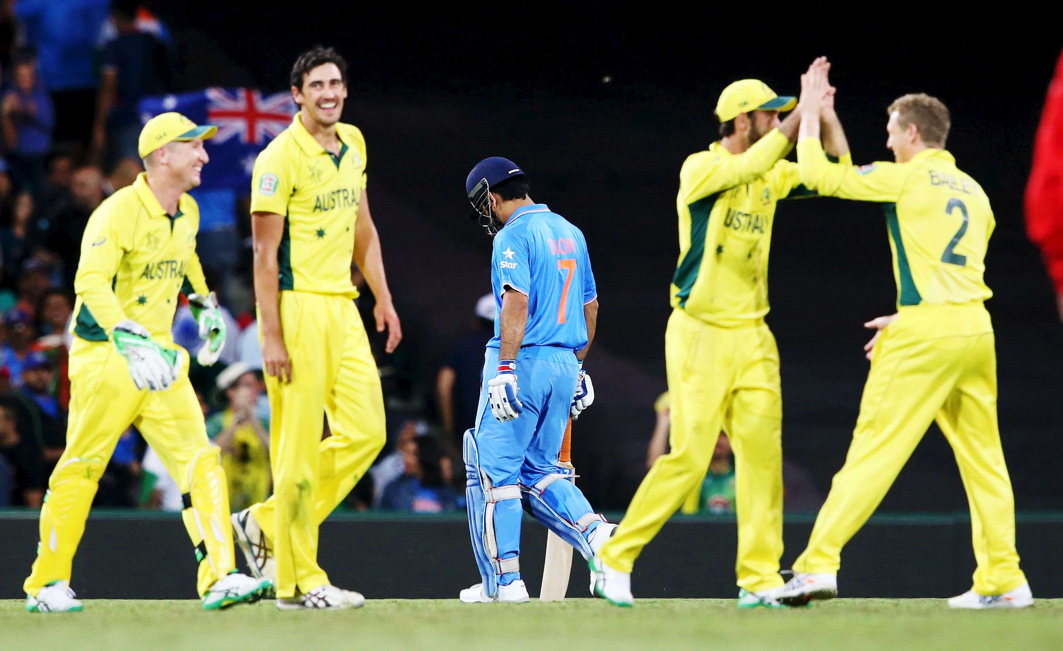 India's captain MS Dhoni walks off the pitch as Australian team mates celebrate being run out by Glenn Maxwell during their Cricket World Cup semi-final match against India in Sydney