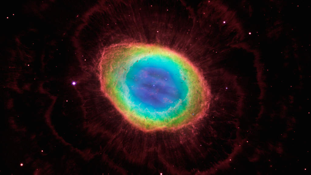 Ring Nebula: The Ring Nebula is the glowing remains of a Sun-like star. The blue gas in the nebula's center is actually a football-shaped structure that pierces the red doughnut-shaped material. Hubble also uncovered the detailed structure of the dark, irregular knots of dense gas embedded along the inner rim of the ring. The faint, scallop-shaped material surrounding the ring was expelled by the star during the early stages of nebula formation. This outer material was imaged by the Large Binocular Telescope. (Courtesy: http://hubblesite.org/)