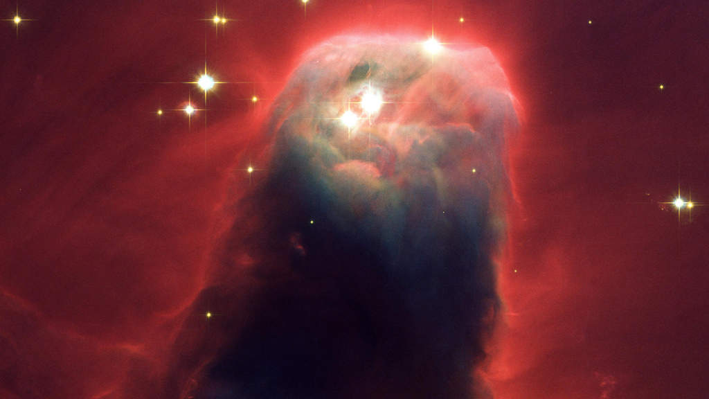 Cone Nebula: Resembling a nightmarish beast rearing its head from a crimson sea, this monstrous object is actually an innocuous pillar of gas and dust. Radiation from hot, young stars located beyond the top of the image has slowly eroded the nebula over millions of years. Ultraviolet light heats the edges of the dark cloud, releasing gas into surrounding space. There, additional ultraviolet radiation causes the hydrogen gas to glow, which produces the red halo of light around the pillar.  (Courtesy: http://hubblesite.org/)