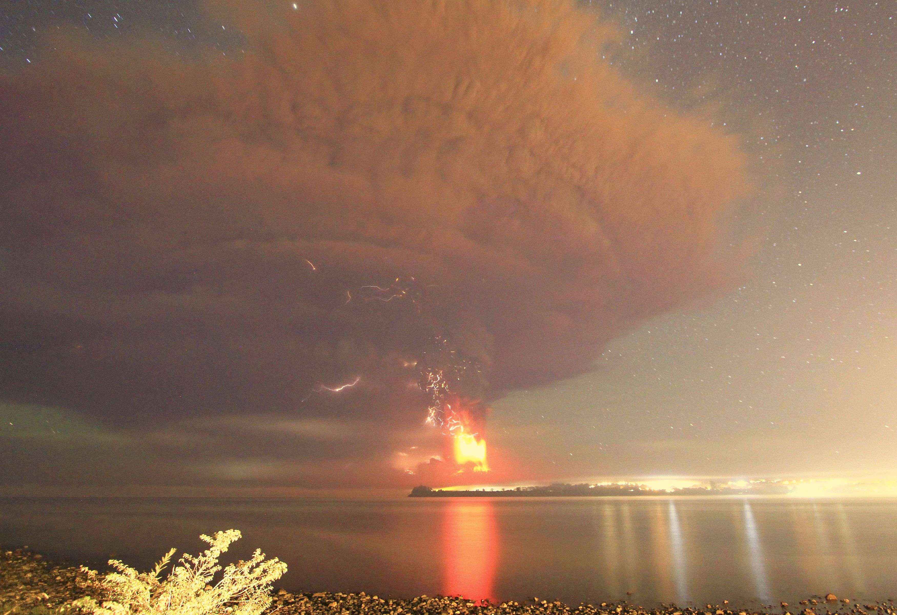 Smoke and lava spew from the Calbuco volcano, as seen from the shores of Lake Llanquihue in Puerto Varas
