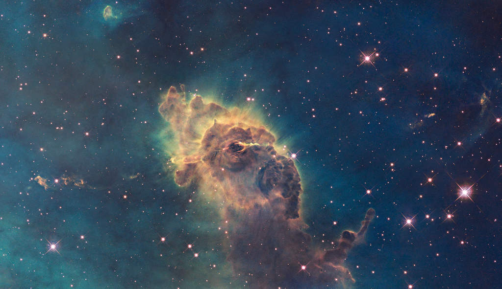 Jet in Carina: Composed of gas and dust, the pillar resides in a tempestuous stellar nursery called the Carina Nebula, located 7,500 light-years away in the southern constellation Carina. Scorching radiation and fast winds (streams of charged particles) from nearby stars are sculpting the pillar and causing new stars to form within it. Streamers of gas and dust can be seen flowing off the top of the structure.  (Courtesy: http://hubblesite.org/)