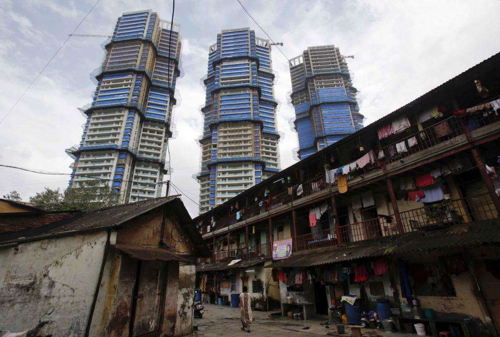 High-rise residential towers under construction are pictured behind an old residential building in central Mumbai. (REUTERS/Vivek Prakash/Files)