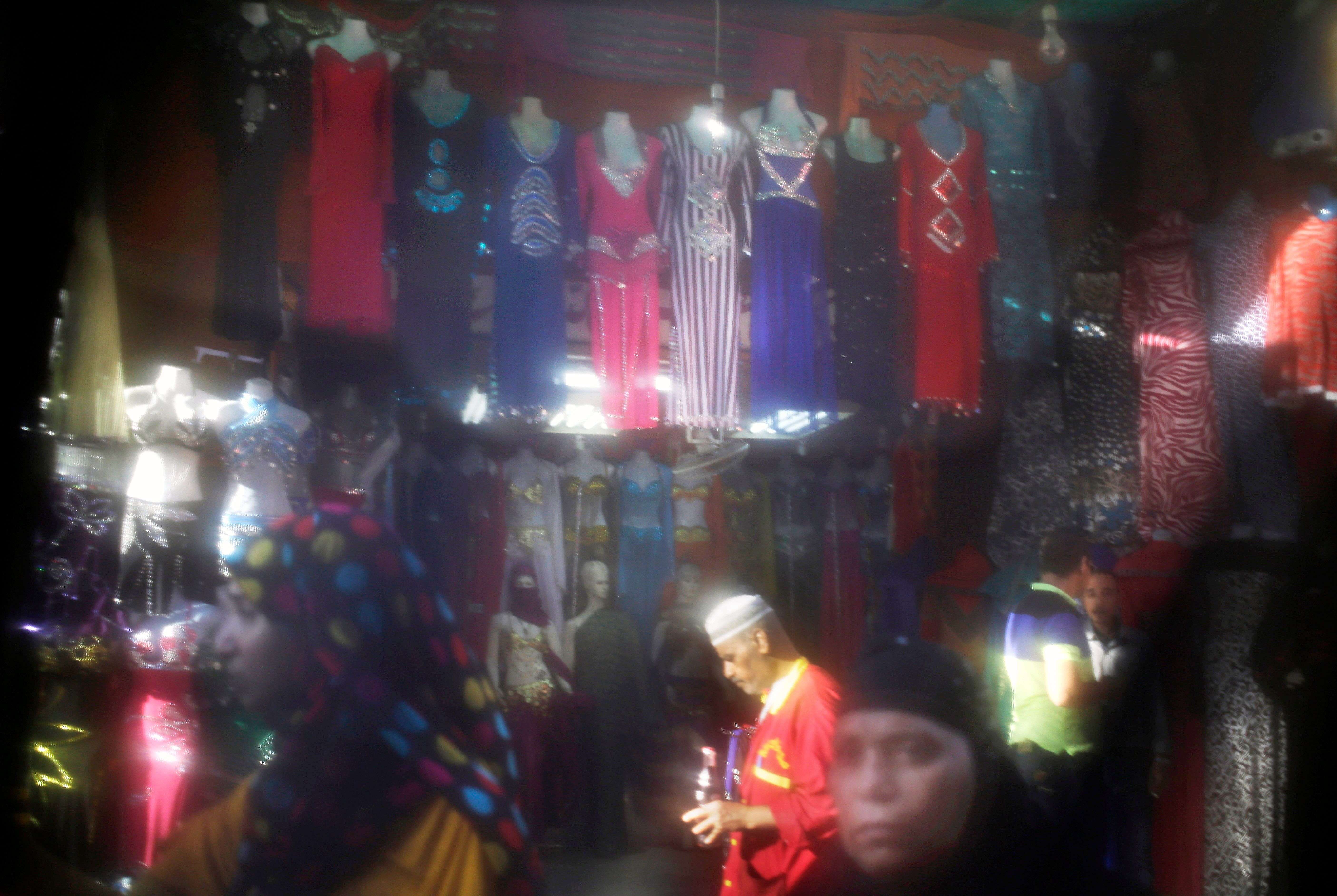 Shoppers wander past a stall selling belly dancer outfits at the Khan el-Khalili market in Cairo, Egypt 