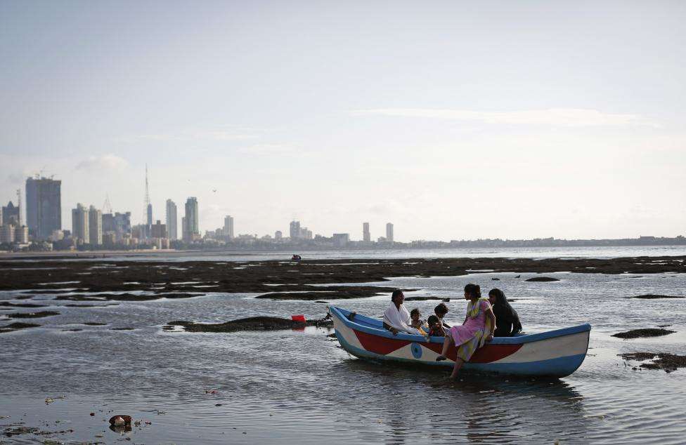 A family sits in an anchored boat in low waters in the Arabian Sea, off the coast of Mumbai. (REUTERS/Danish Siddiqui/Files)