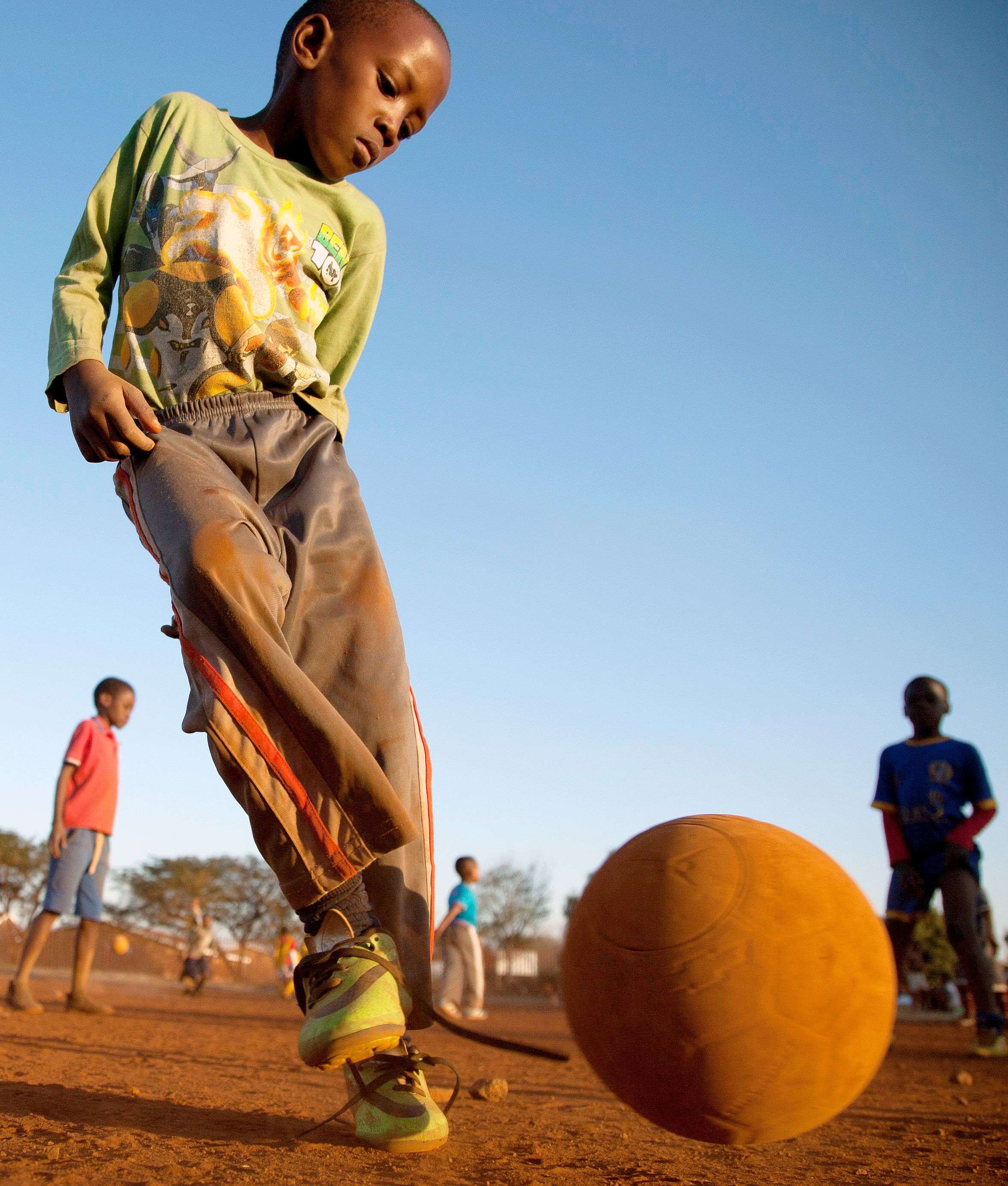 Young boys play soccer on a dusty field in Thokoza township east of Johannesburg, South Africa.(AP/Themba Hadebe) 