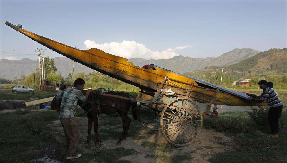 Kashmiri men unload a boat from a horse cart near Dal Lake in Srinagar. (REUTERS/Danish Ismail/Files)