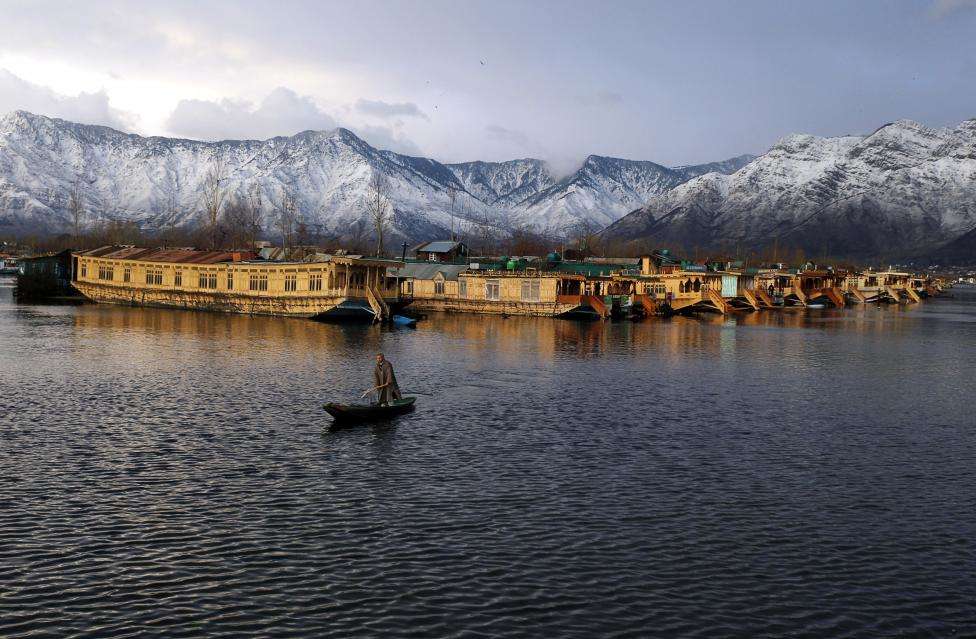 A Kashmiri man rows his boat in the waters of the Dal Lake on a cold winter evening in Srinagar. (REUTERS/Danish Ismail/Files)