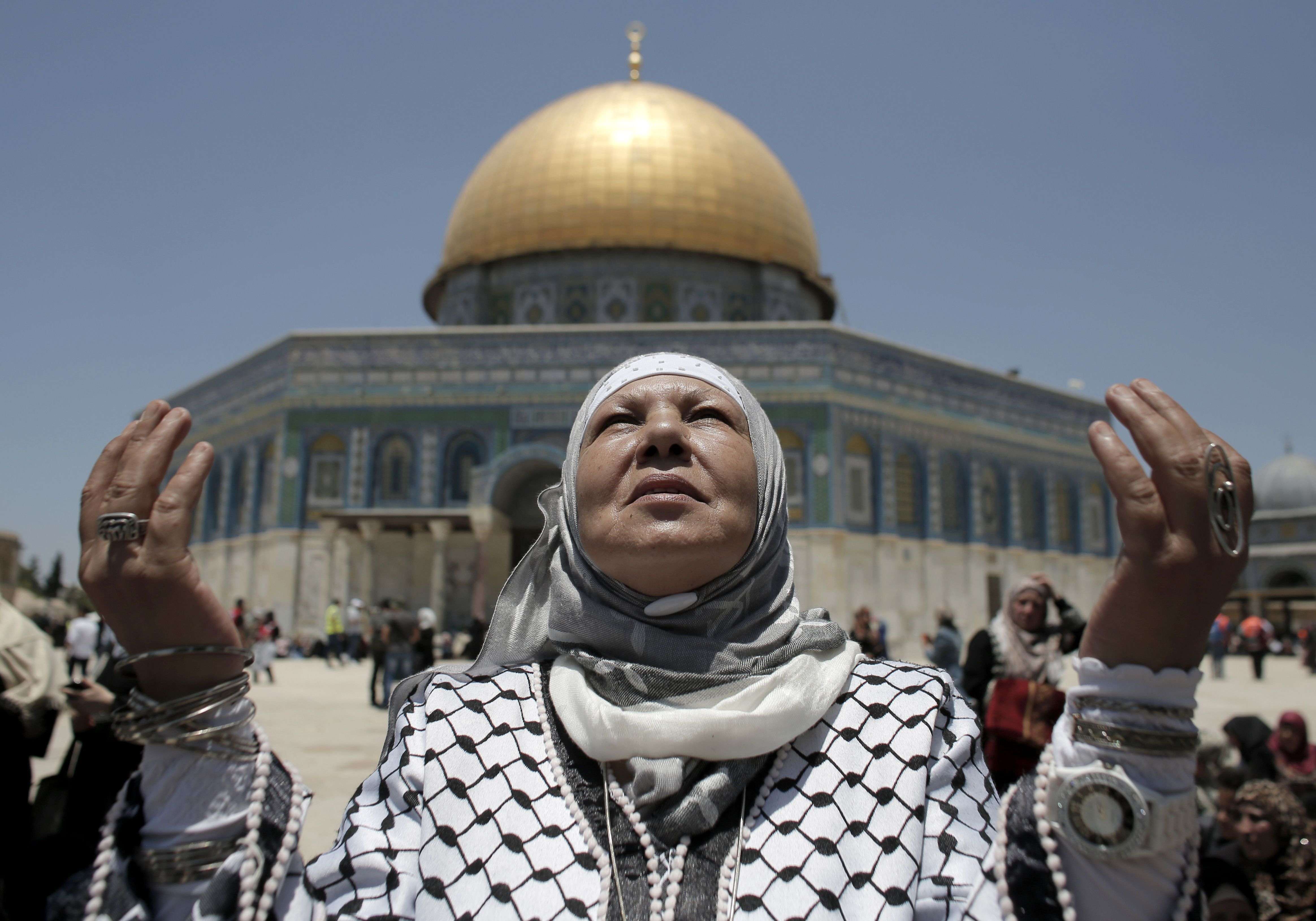 Palestinian women pray outside the Dome of the Rock at the Al-Aqsa Mosque compound in Jerusalem. (AFP PHOTO / AHMAD GHARABLI)