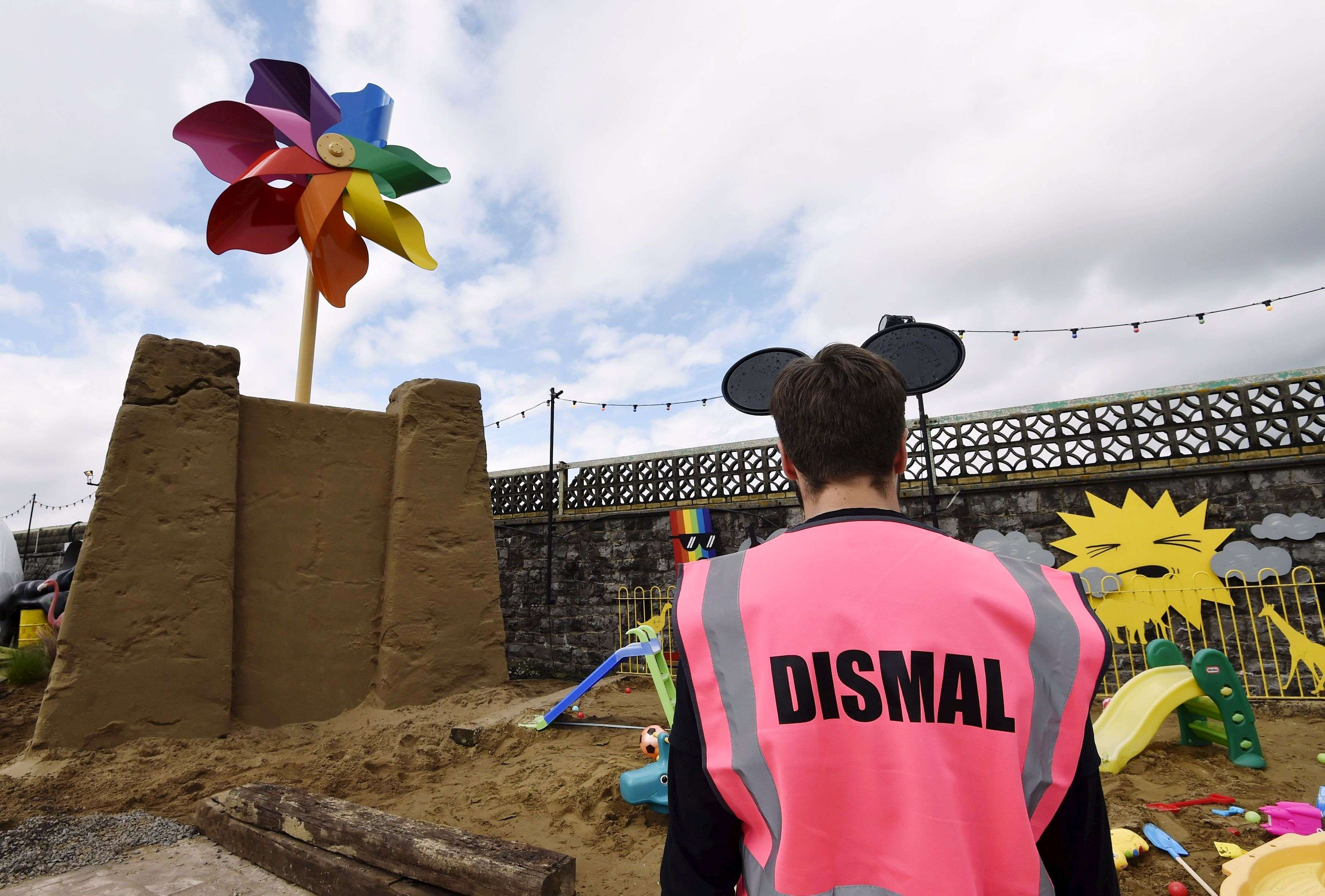 A performer is pictured in front of a sculpture at 'Dismaland', a theme park-styled art  installation by British artist Banksy, at Weston-Super-Mare in southwest England, Britain, August 20, 2015. REUTERS/Toby Melville