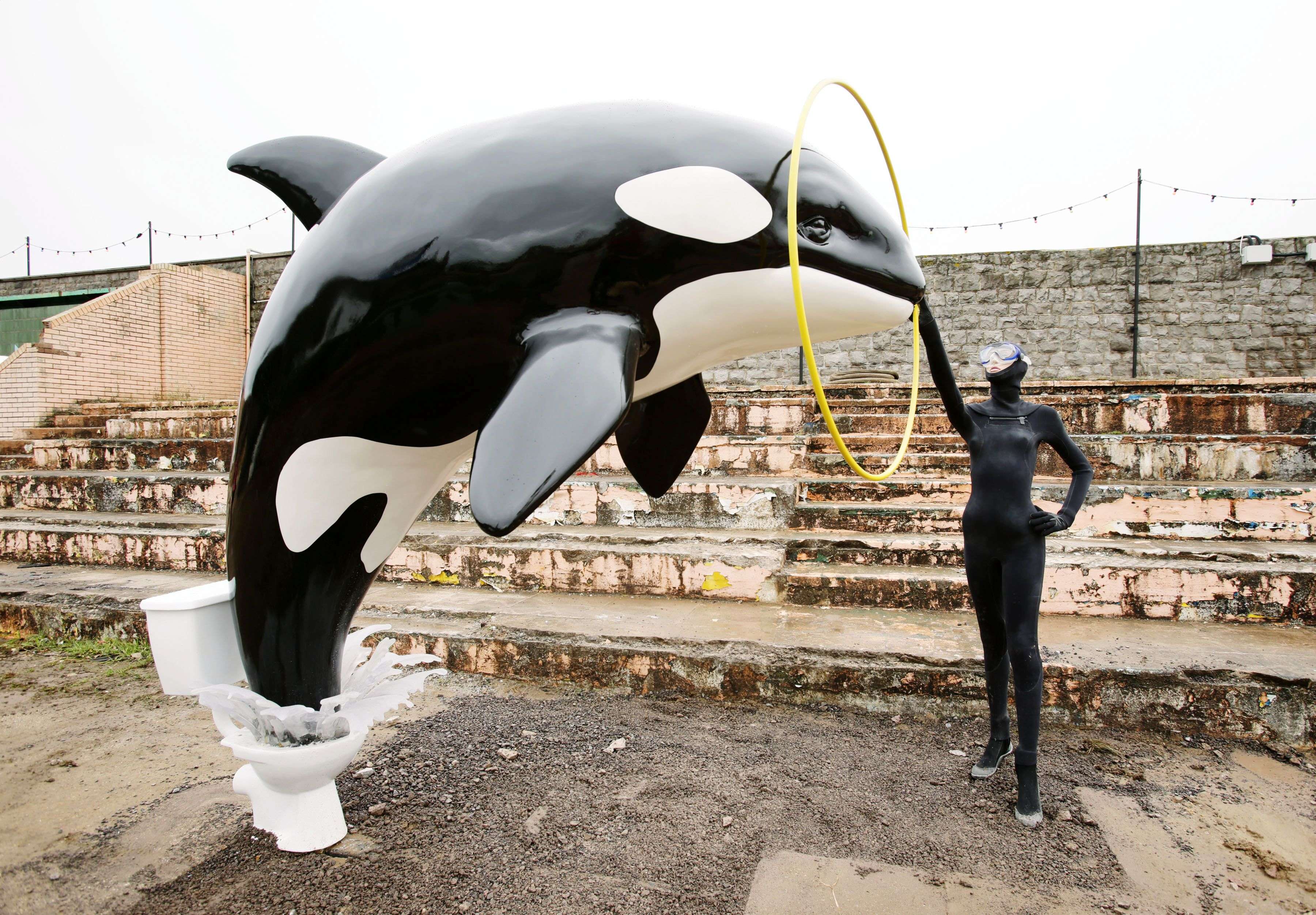 A Banksy piece depicting an orca whale jumping out of a toilet is displayed at Banksy's biggest show to date, entitled 'Dismaland', during a press viewing in Western-super-Mare, Somerset, England, Thursday, Aug. 20, 2015. (Yui Mok/PA Wire via AP) UNITED KINGDOM OUT, NO SALES, NO ARCHIVE