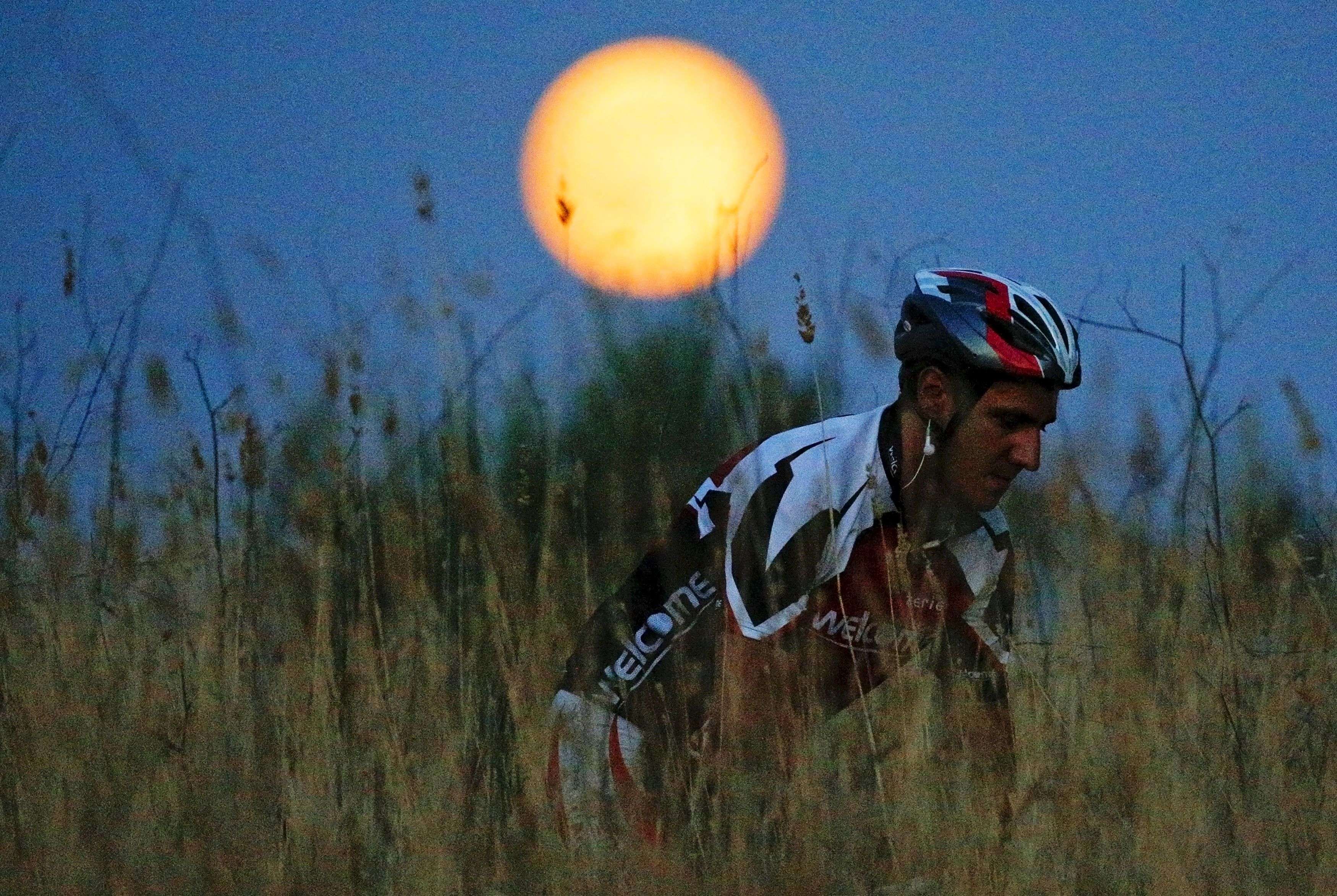 A cyclist rides his mountain bike as a full moon, known as the Blue Moon, rises in a park in Rome, Italy, July 31, 2015. REUTERS/Max Rossi      TPX IMAGES OF THE DAY