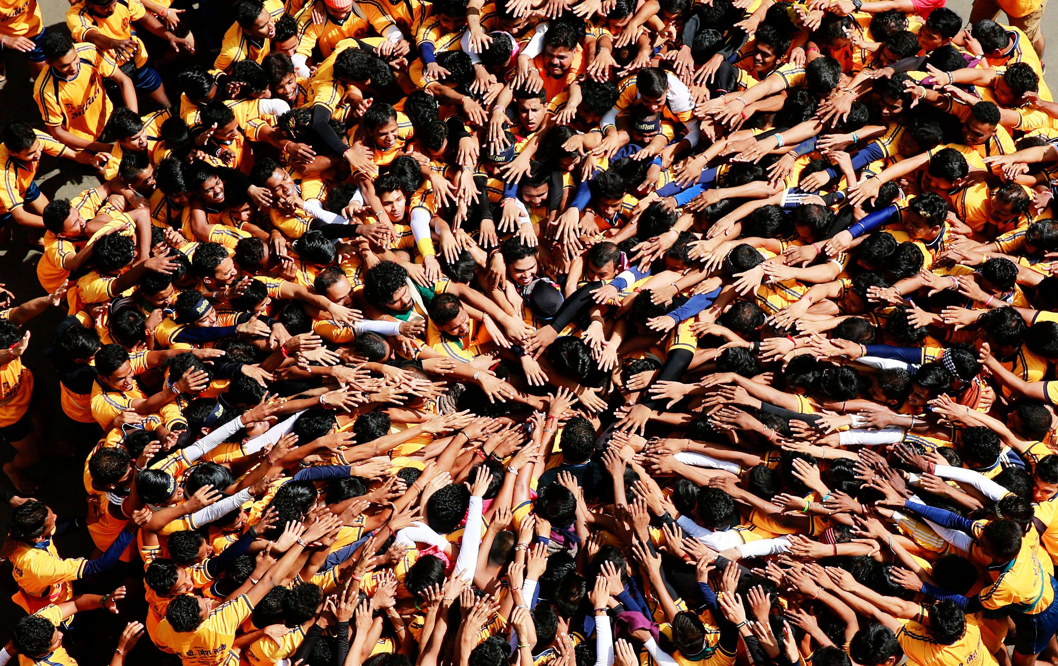 Indian youth form a human pyramid to break the "Dahi handi," an earthen pot filled with curd hanging above, an integral part of celebrations to mark Janmashtami festival in Mumbai, India, Sunday, Sept 6. 2015. The festival marks the birth of Hindu god Krishna and the act seeks to reenact the story of Lord Krishna stealing butter during his childhood.(AP Photo/Rafiq Maqbool)