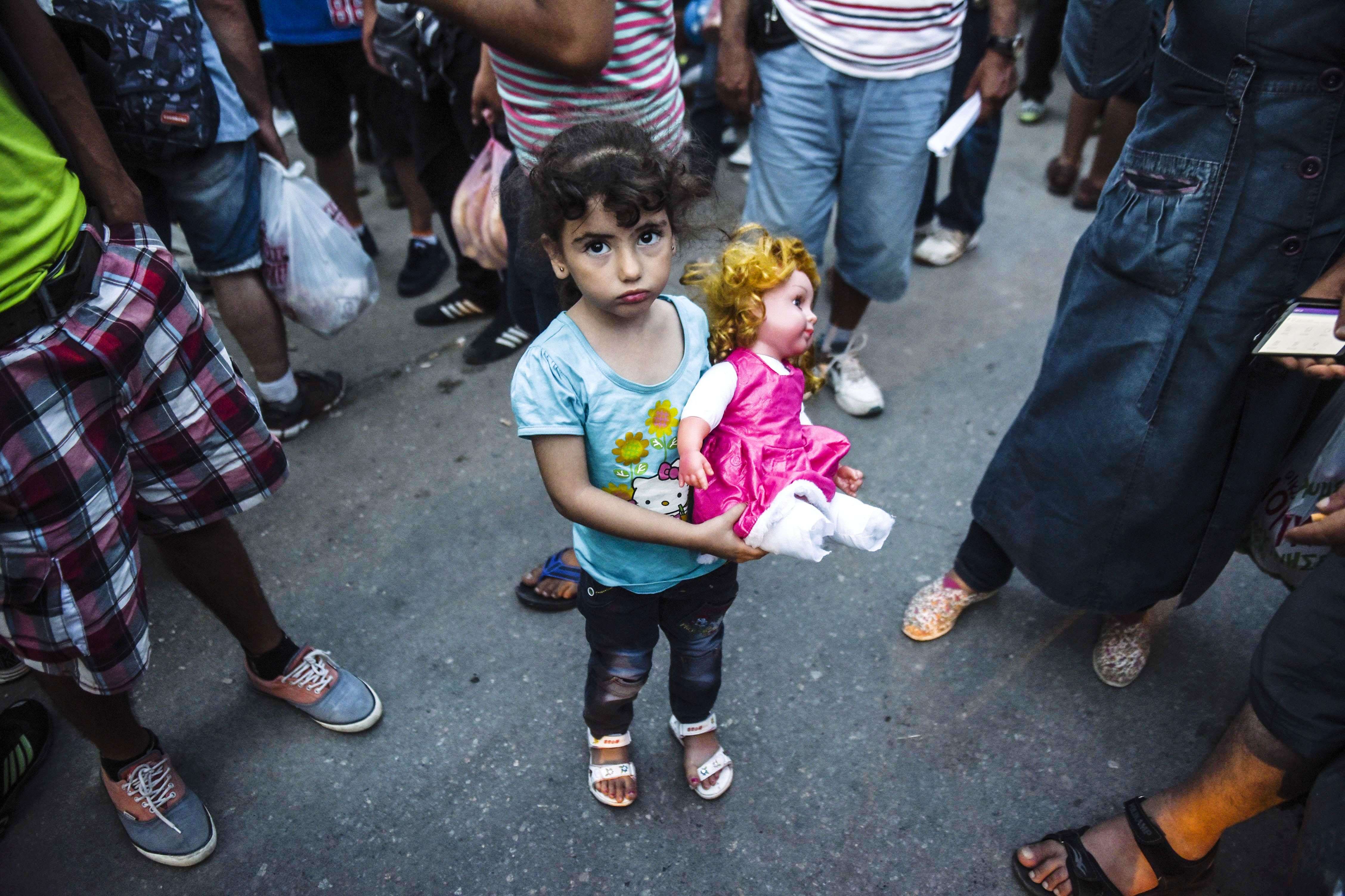 A girl holding a doll, arrives with others migrants at the refugee center in the town of Presevo, after walking from Macedonia to Serbia. (AFP PHOTO / ARMEND NIMANI)