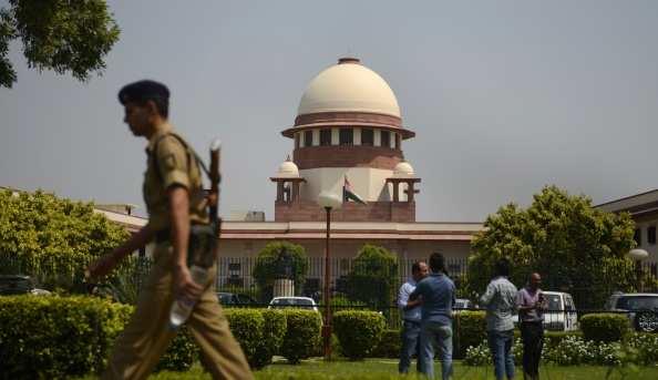 A security personel walks in front of the Indian Supreme court in New Delhi on August 27, 2014.  India's top court said lawmakers with criminal backgrounds should not serve in government, with 13 ministers facing charges for attempted murder, rioting and other offences. The ruling is likely to put pressure on right-wing Prime Minister Narendra Modi, who swept to power this year pledging clean governance.    AFP PHOTO/ SAJJAD HUSSAIN        (Photo credit should read SAJJAD HUSSAIN/AFP/Getty Images)