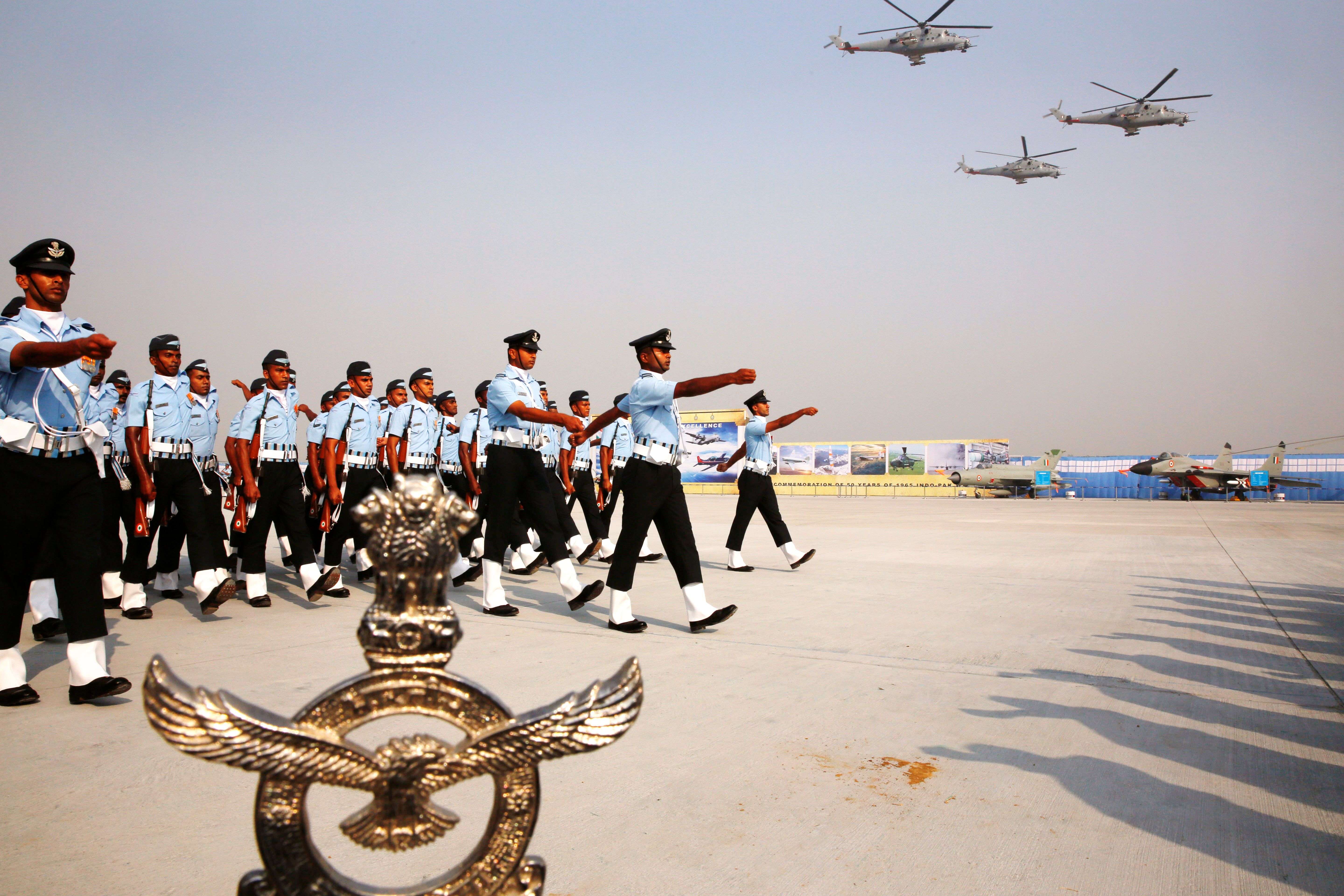 Indian Air Force Mi-35 helicopters fly above  soldiers marching during the Air Force Day parade at Hindon Air Force base near New Delhi, India, Thursday, Oct. 8, 2015. Air Chief Marshal Arup Raha announced Thursday that the IAF would soon have women fighter pilots. (AP Photo/Manish Swarup)