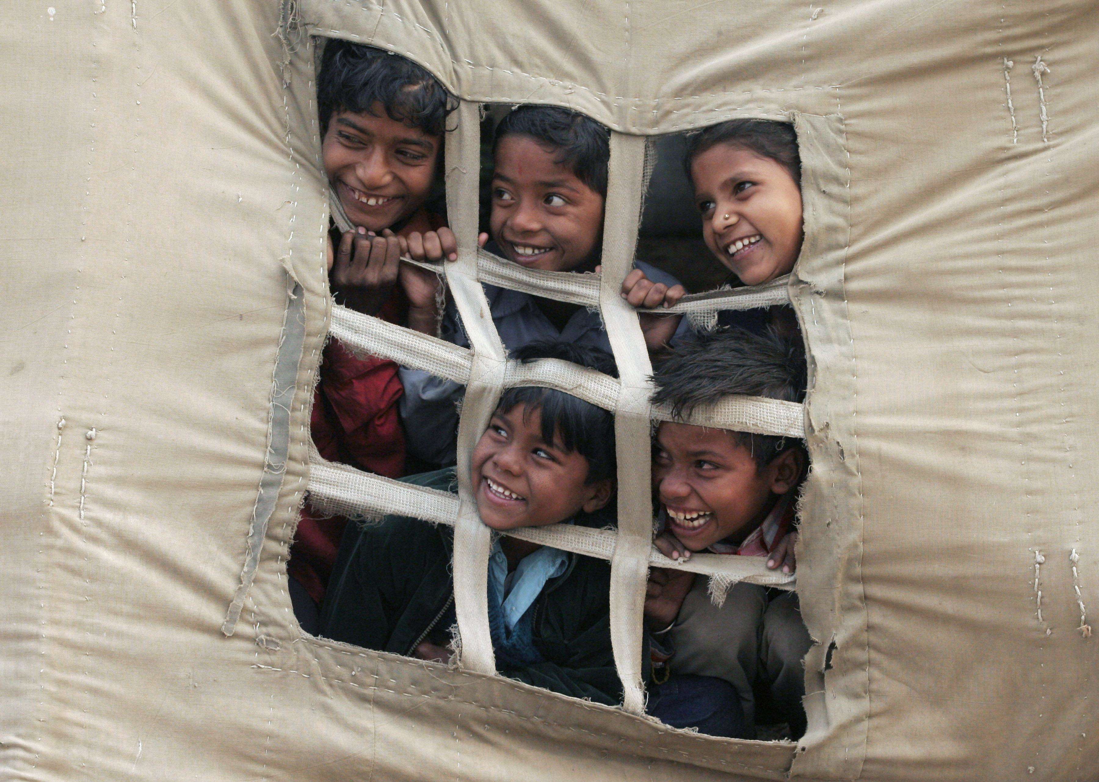 ** FOR USE AS DESIRED WITH YEAR END--FILE **In this Feb. 6, 2008 file photo, Indian children peek out of a tent at Sangam, the confluence of the Ganges and Yamuna rivers during the annual traditional fair of Magh Mela in Allahabad, India. (AP Photo/Rajesh Kumar Singh/FILE)