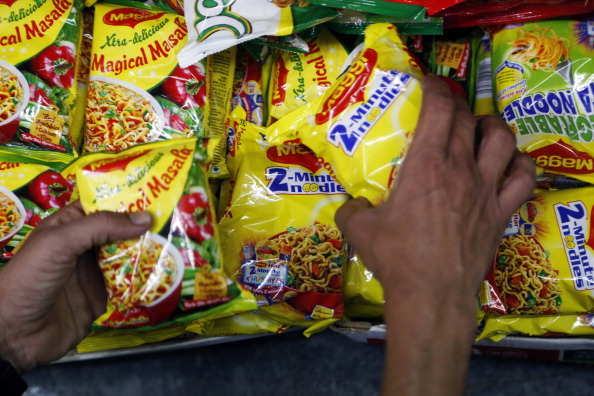 A shop assistant arranges packets of Maggi 2-Minute Noodles and Xtra-delicious Magical Masala, both manufactured by Nestle India Ltd., at a general store in Mumbai, India, on Wednesday, Feb. 12, 2014. Nestle India Ltd. is scheduled to release fourth-quarter earnings on Feb. 14. Photographer: Vivek Prakash/Bloomberg via Getty Images
